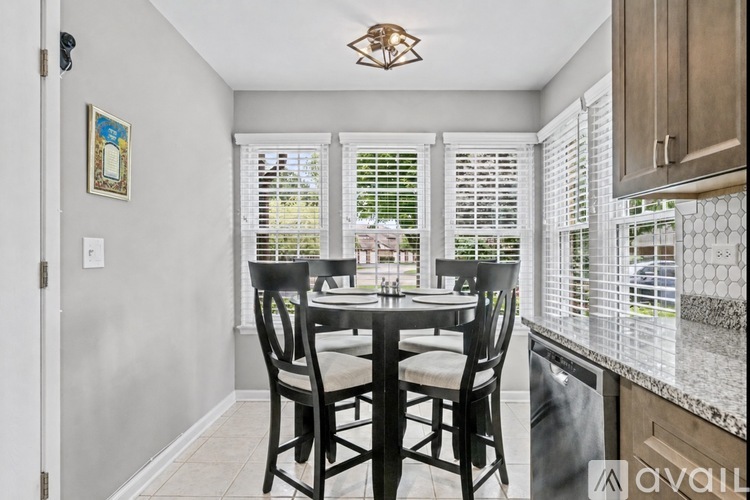 A dining room with a table set for two and a window with blinds.