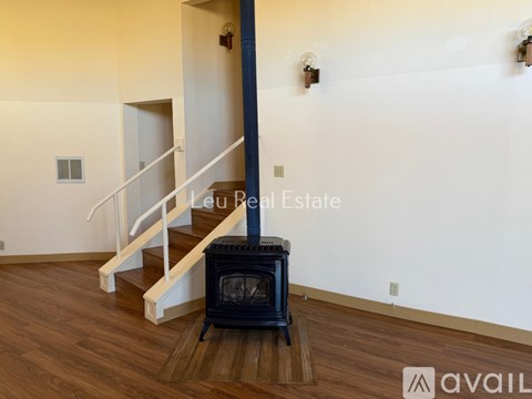 A living room with a wood floor and a wood stove.