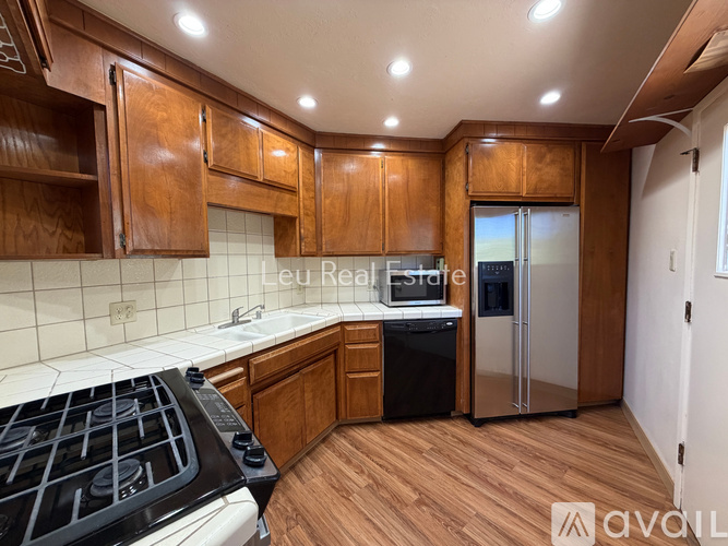 A kitchen with wooden cabinets and a black stove top.
