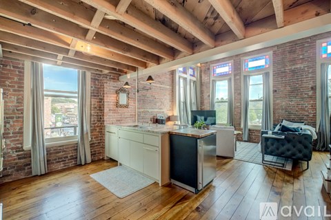 A kitchen with wooden floors and a brick wall.