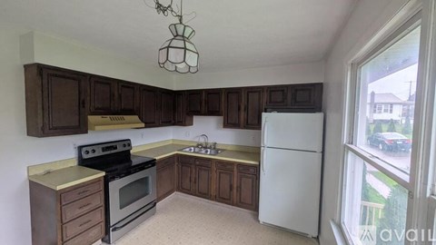 A kitchen with a white fridge and wooden cabinets.