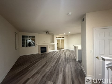 A spacious living room with a fireplace and hardwood floors.