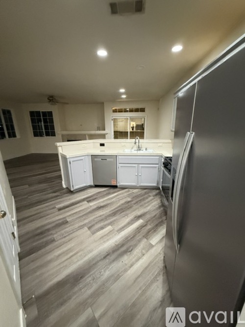 A kitchen with a refrigerator on the right side.