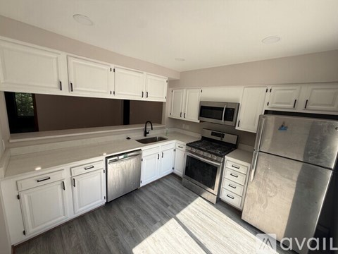 A kitchen with white cabinets and stainless steel appliances.