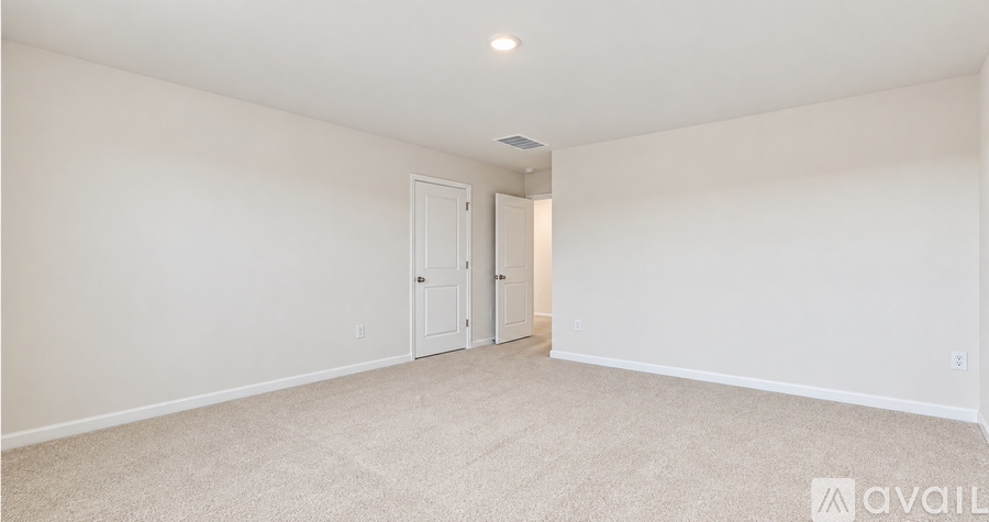 A spacious room with a carpeted floor and two doors.