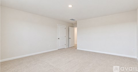 A spacious room with a carpeted floor and two doors.