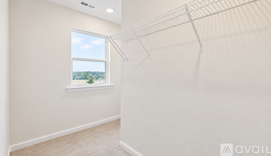 Empty room with a window and a view of trees outside.