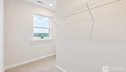 Empty room with a window and a view of trees outside.