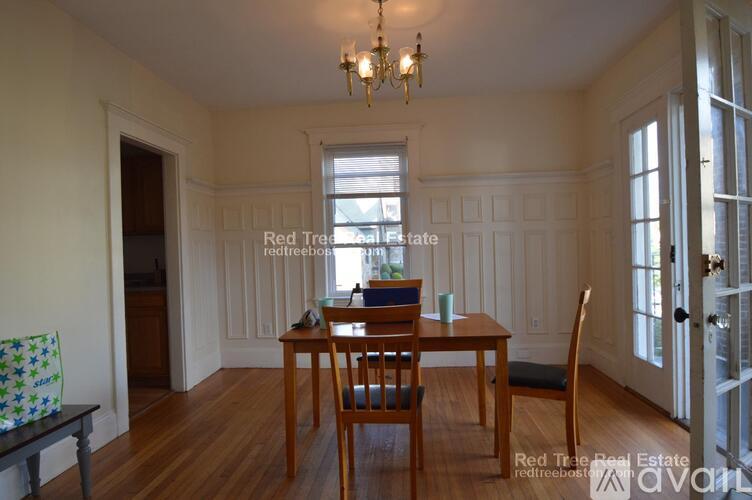 A dining room with a wooden table and chairs.