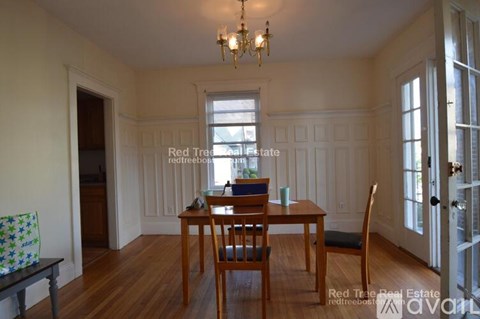 A dining room with a wooden table and chairs.