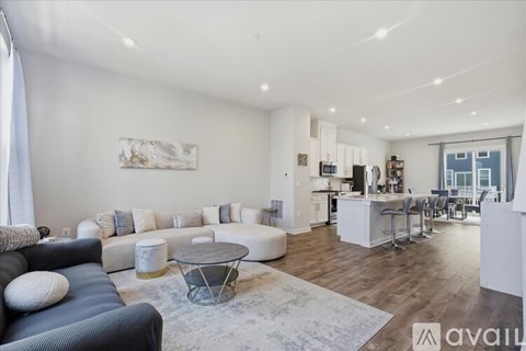A spacious living room with a black couch and a coffee table in the center.