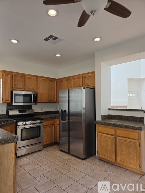 A kitchen with wooden cabinets and a stainless steel refrigerator.
