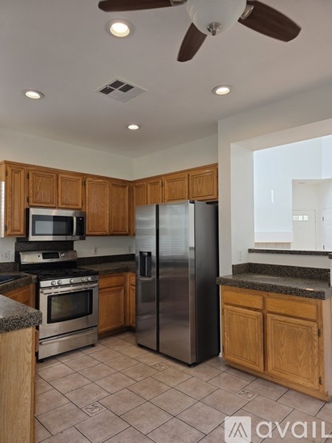 A kitchen with wooden cabinets and a stainless steel refrigerator.