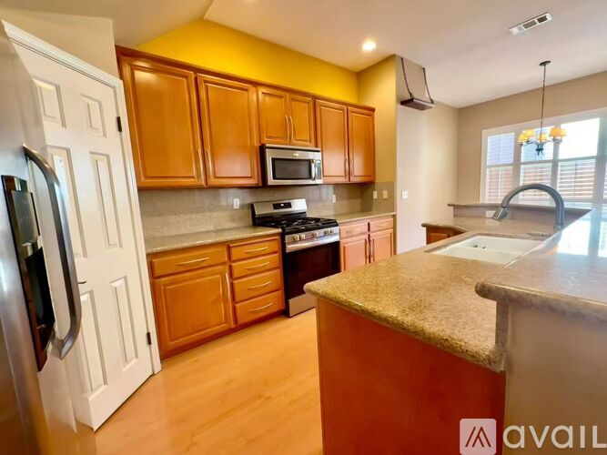 A kitchen with wooden cabinets and a refrigerator.