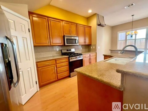 A kitchen with wooden cabinets and a refrigerator.