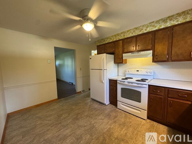 A kitchen with a white refrigerator and stove top oven.