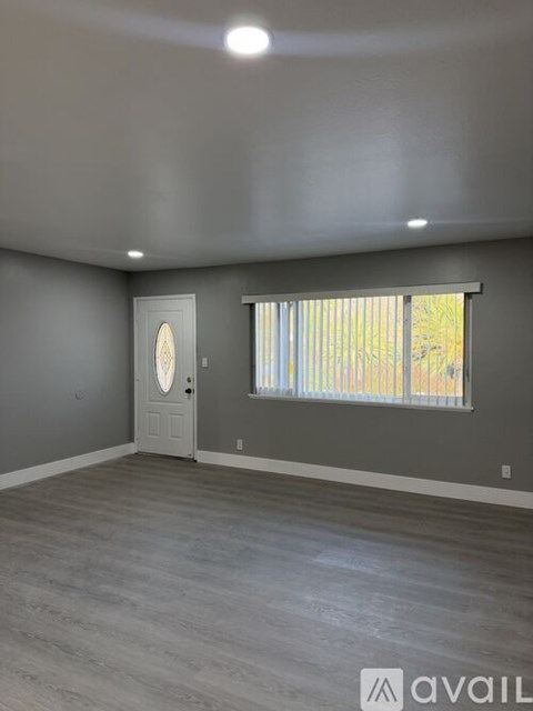 A room with a door and a window with blinds.