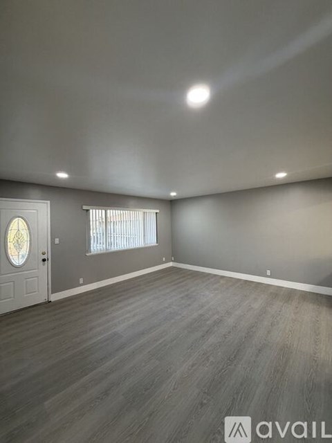 A room with a wooden floor and a white door.