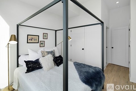 A bedroom with a four poster bed and a white bedspread.