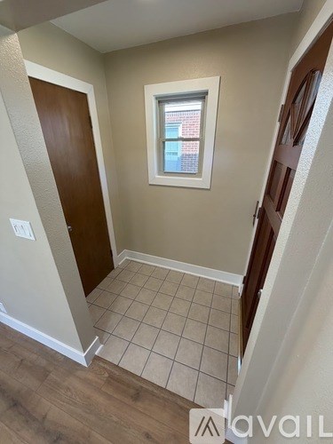 A room with a tiled floor and a window showing a building outside.