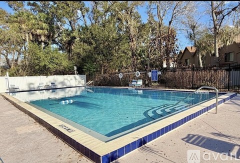 A small pool with a blue tiled edge and a white wall on the side.
