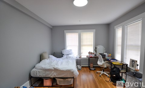 A bedroom with a bed, desk, and chair.