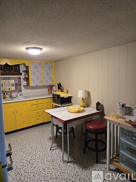 A kitchen with a table and chairs.