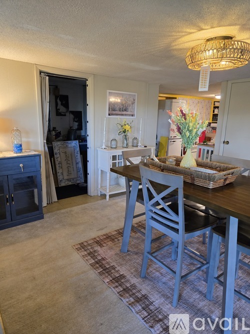 A dining room with a wooden table and chairs.