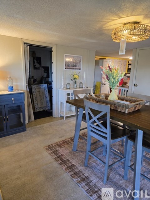 A dining room with a wooden table and chairs.