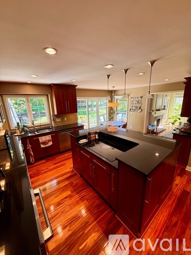 A kitchen with red cabinets and a black countertop.