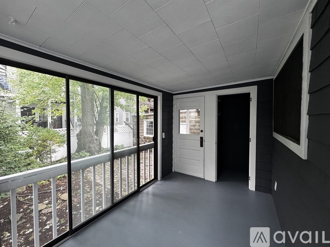 A balcony with a view of trees and a building outside.