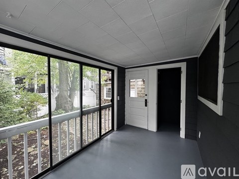 A balcony with a view of trees and a building outside.