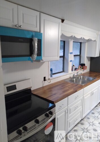 A kitchen with white cabinets and a black stove top oven.