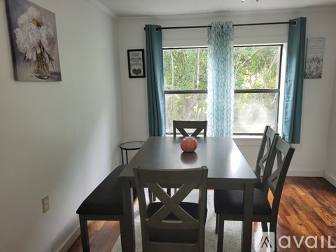 A dining room with a table and chairs.