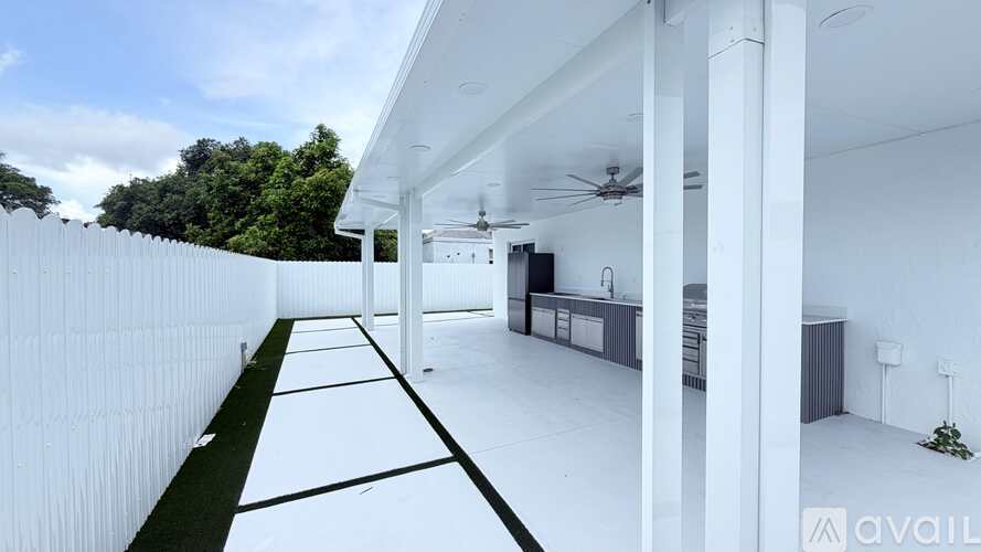 A modern house with a white exterior and a long white fence.