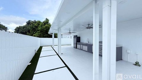 A modern house with a white exterior and a long white fence.