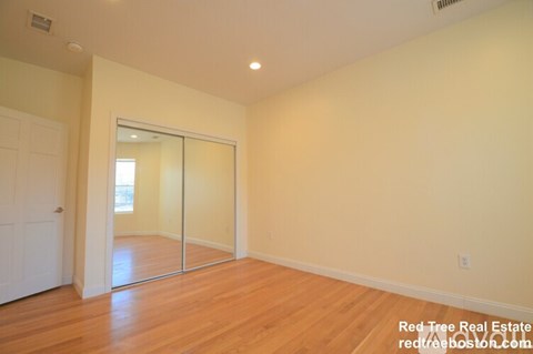 A room with a sliding glass door leading to a balcony.