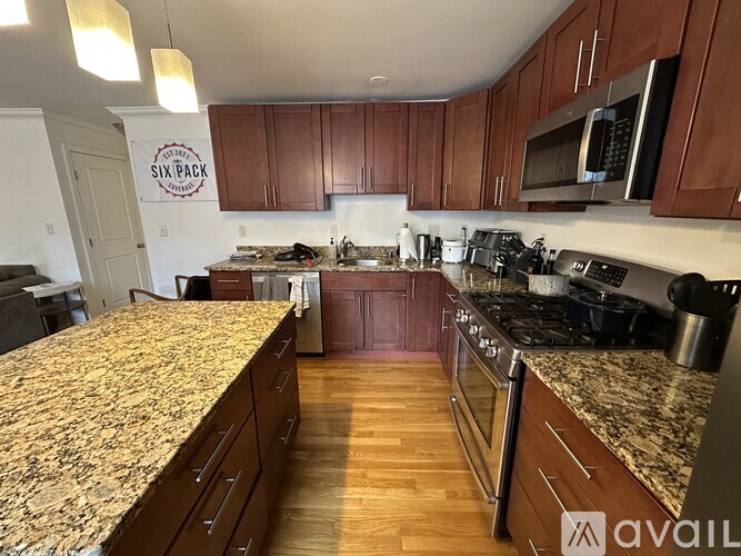 A kitchen with brown cabinets and granite countertops.