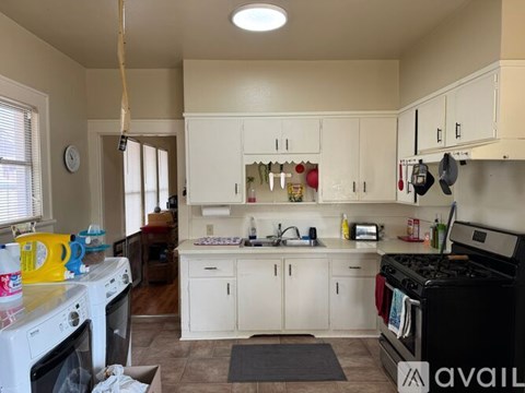 A kitchen with white cabinets and a black stove top oven.
