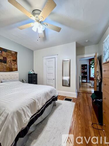 A bedroom with a bed, dresser, and mirror.