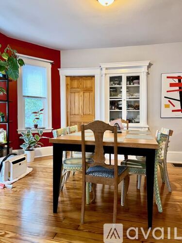 A dining room with a wooden table and chairs.