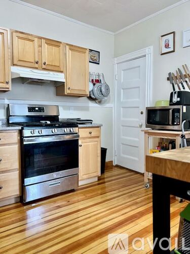 A kitchen with wooden floors and a stove top oven.