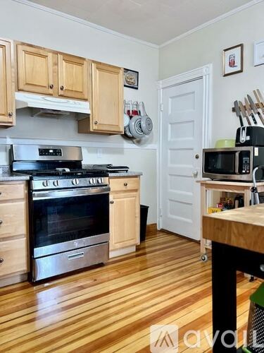 A kitchen with wooden floors and a stove top oven.