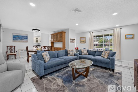 A living room with a blue couch and a coffee table.