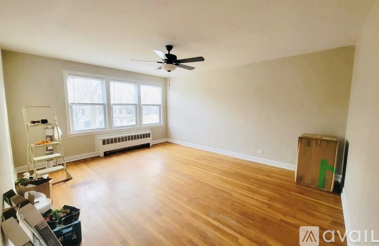 A room with a ceiling fan and wooden flooring.