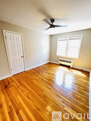 A room with wooden floors and a ceiling fan.