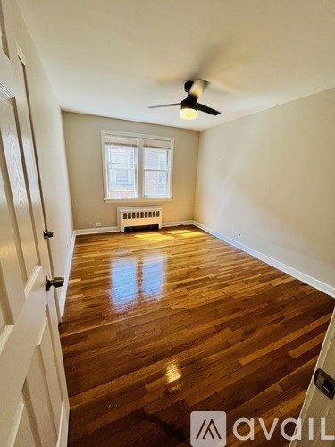 A room with wooden floors and a ceiling fan.