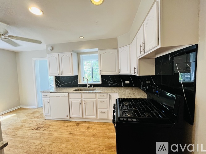 A kitchen with black appliances and white cabinets.