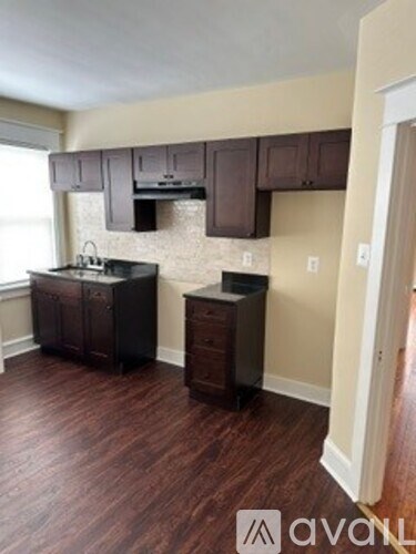 A kitchen with brown cabinets and a black counter top.