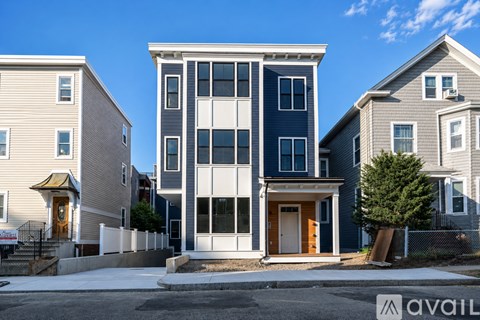 A modern two-story house with a blue and white exterior is shown.